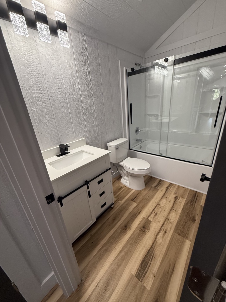 Bathroom vanity with white countertop and modern fixtures in Oklahoma tiny home