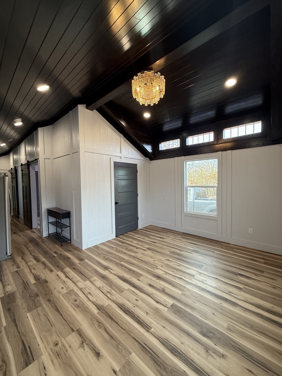 The Classic tiny home living room with premium dark tongue and groove ceiling and crystal chandelier