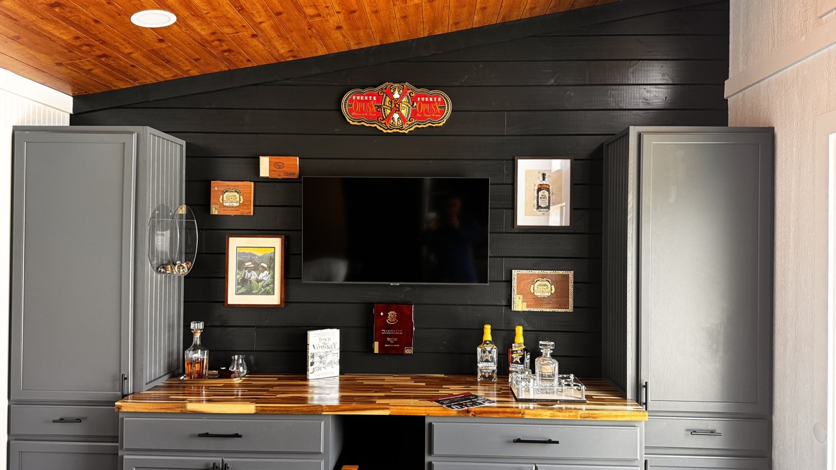 Custom cigar lounge bar with tiger-striped butcher block countertop and gray cabinetry