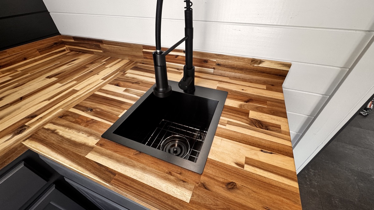 Custom tiger-striped butcher block bar top detail with black undermount sink