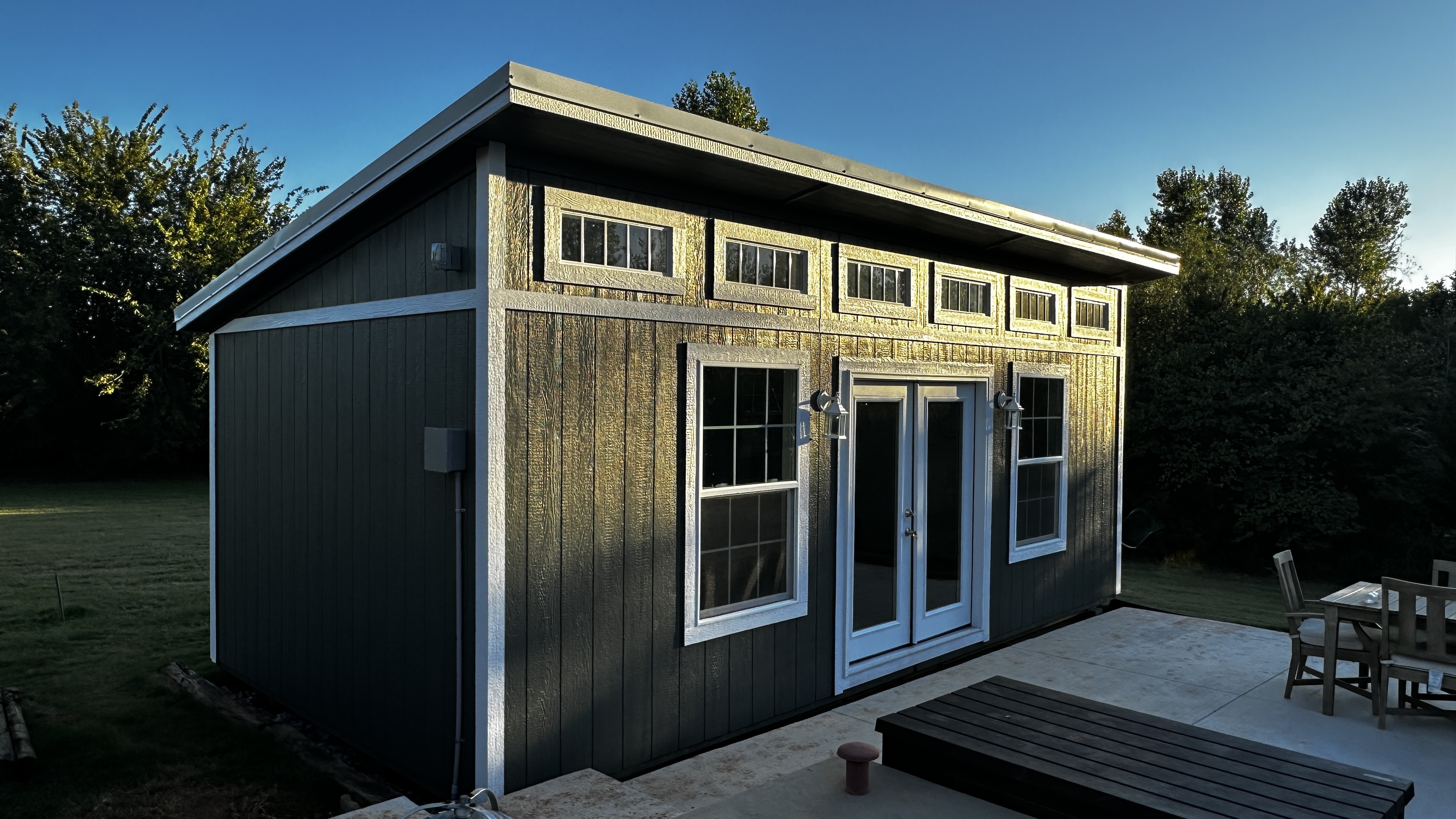 Grey poolhouse with transom windows by Barn Brothers