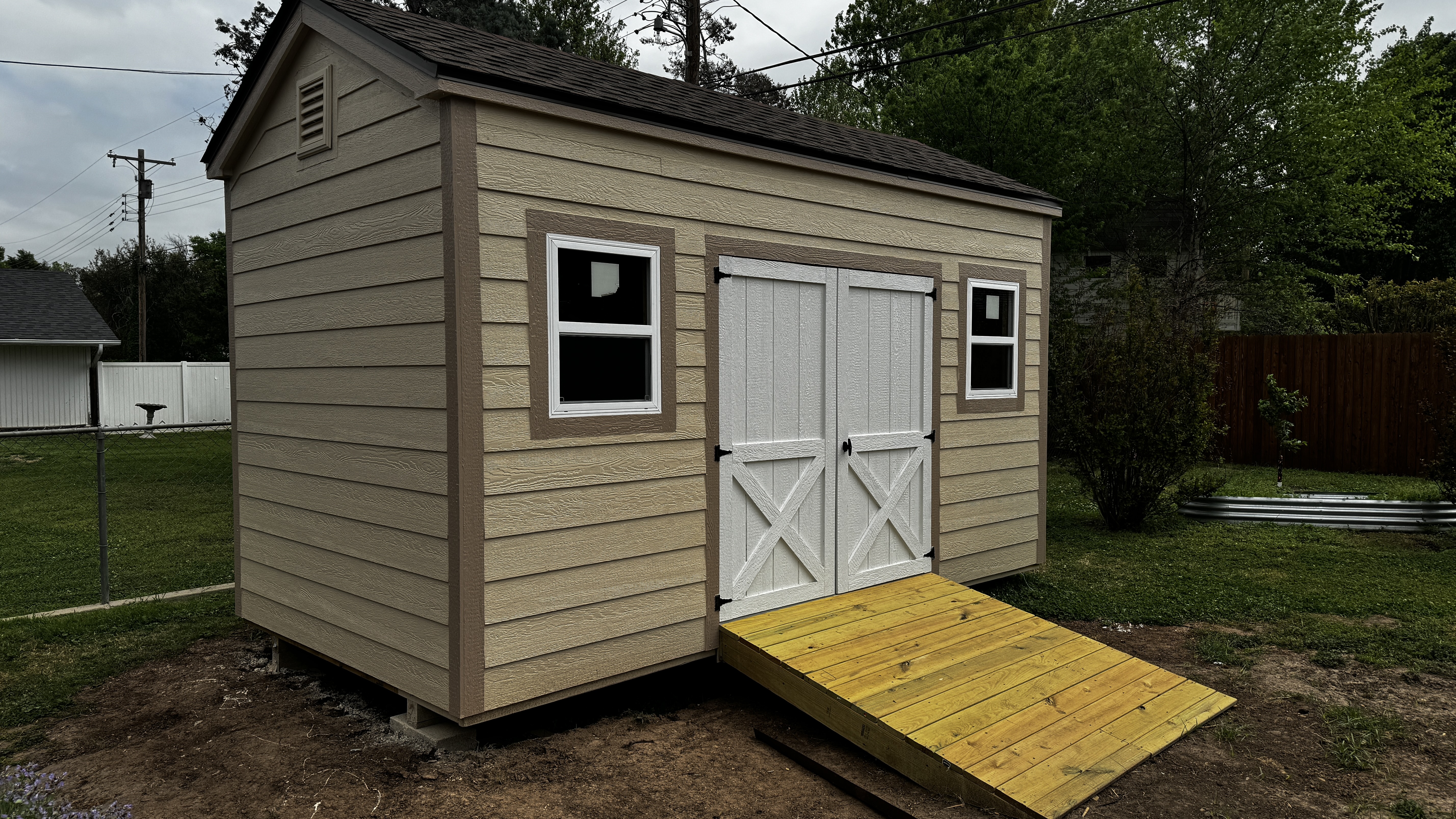 Tan utility shed with ramp delivered by Barn Brothers
